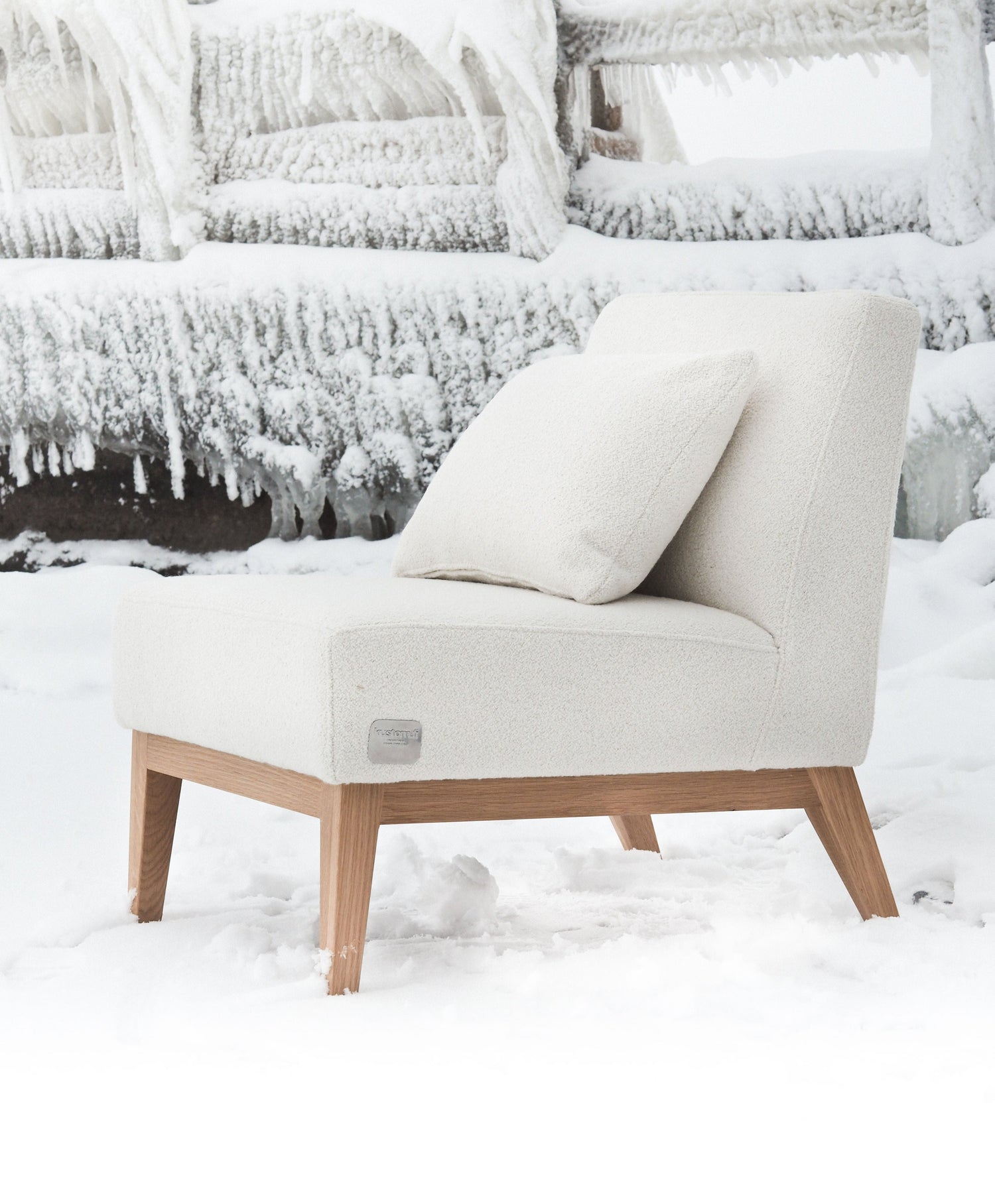 Nagu-nojatuoli valkoisella bukleekankaalla verhoiltuna. Jalat ja kehikko tammea. Tuolilla on valkoinen tyyny.