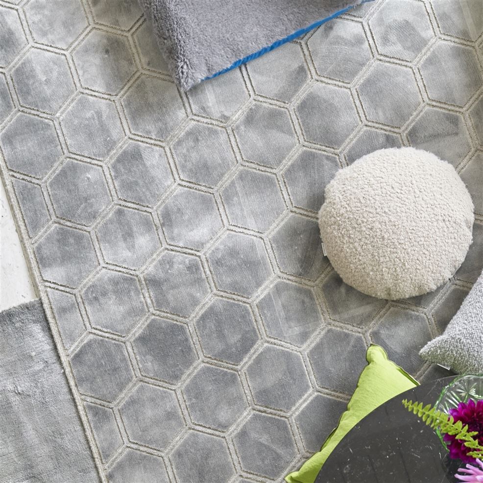 Lattialla hopeanharmaa matto, jossa kuviointina kuusikulmioita.