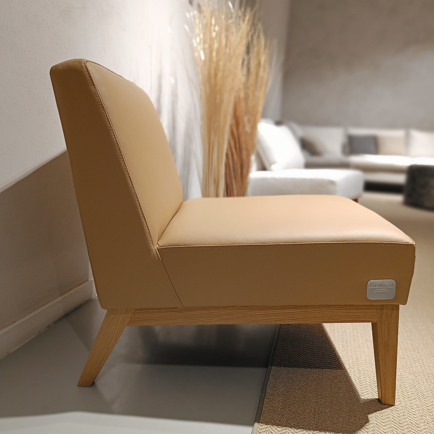 Nagu-nojatuoli, joka on verhoiltu beigellä Linea-nahalla.