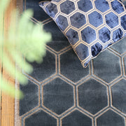 Puulattialla sininen matto, jossa kuusikulmioita. Lattialla myös sininen sisustustyyny, jossa kuusikulmiokuviointi.