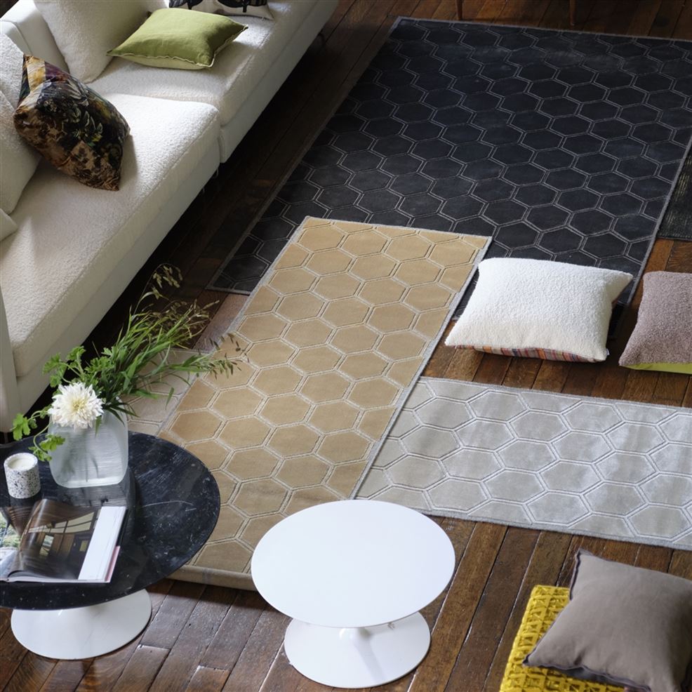 Puulattia, jolla on useita mattoja, kaksi pyöreätä pöytää, luonnonvalkoinen buklee-sohva ja useita sisustustyynyjä.