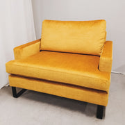 Keltainen, leveä Hetta-nojatuoli mustilla kaarijaloilla. Kangas Jewel 520 Mustard.