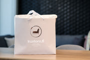 Beige paperikassi, jossa Kustom-logo ja teksti kustom.fi, furniture from Finland since 1970.